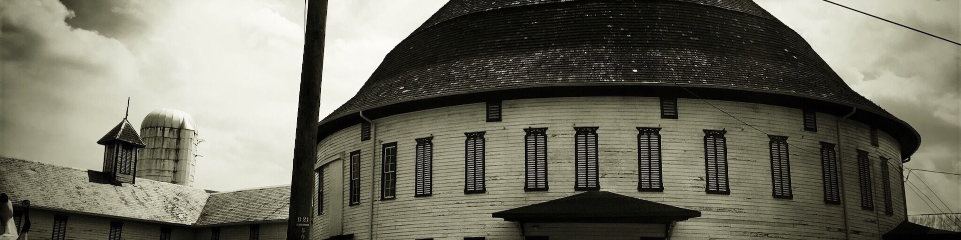 A large, round building with a dome roof and a smaller tower in the background.