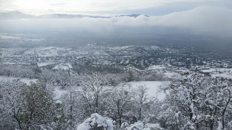 A snow-covered mountainous landscape with a town nestled in the valley below.