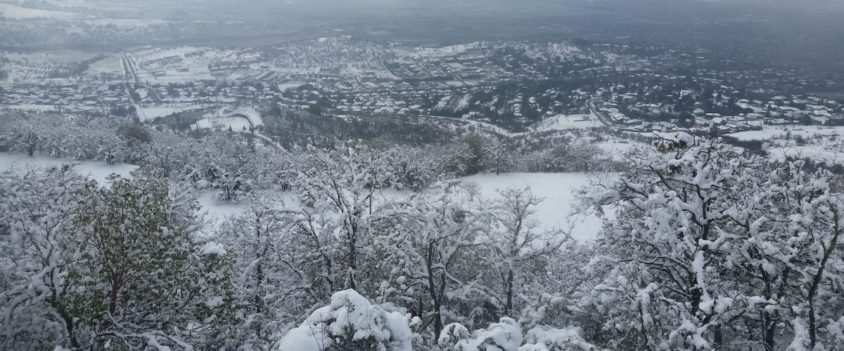 A snow-covered mountainous landscape with a town nestled in the valley below.