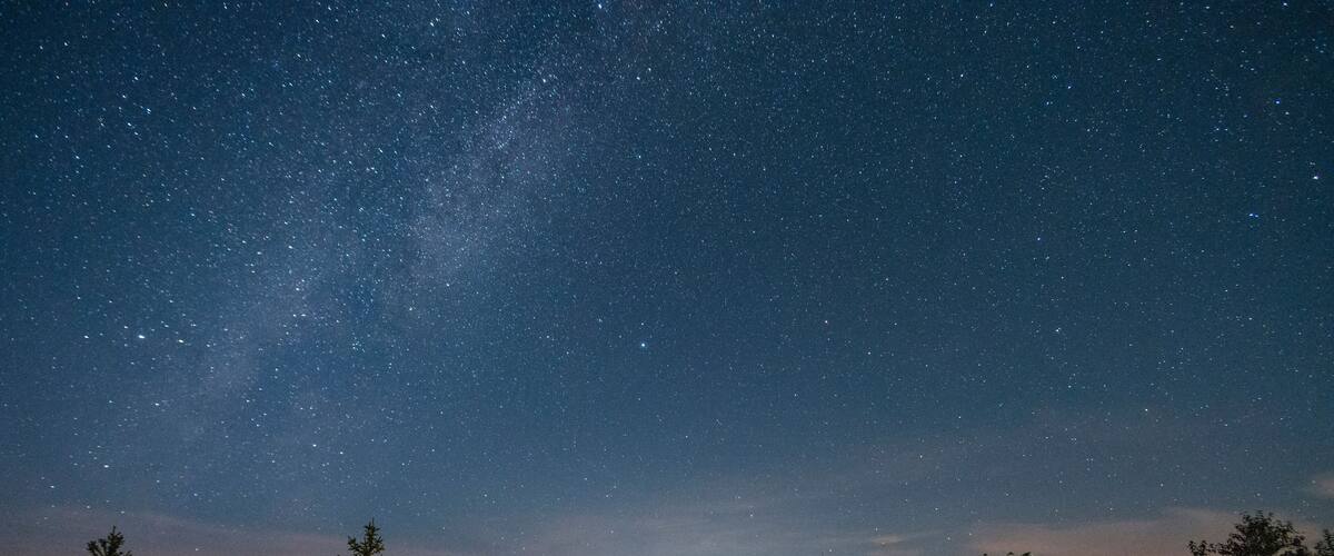 A tent under a starry night sky with a visible Milky Way.
