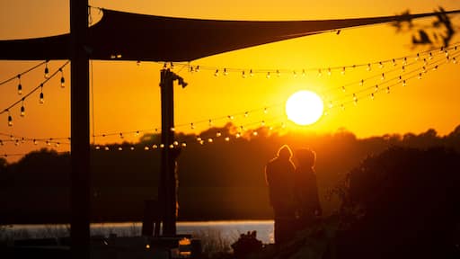A couple standing admiring sunset in Charleston, SC