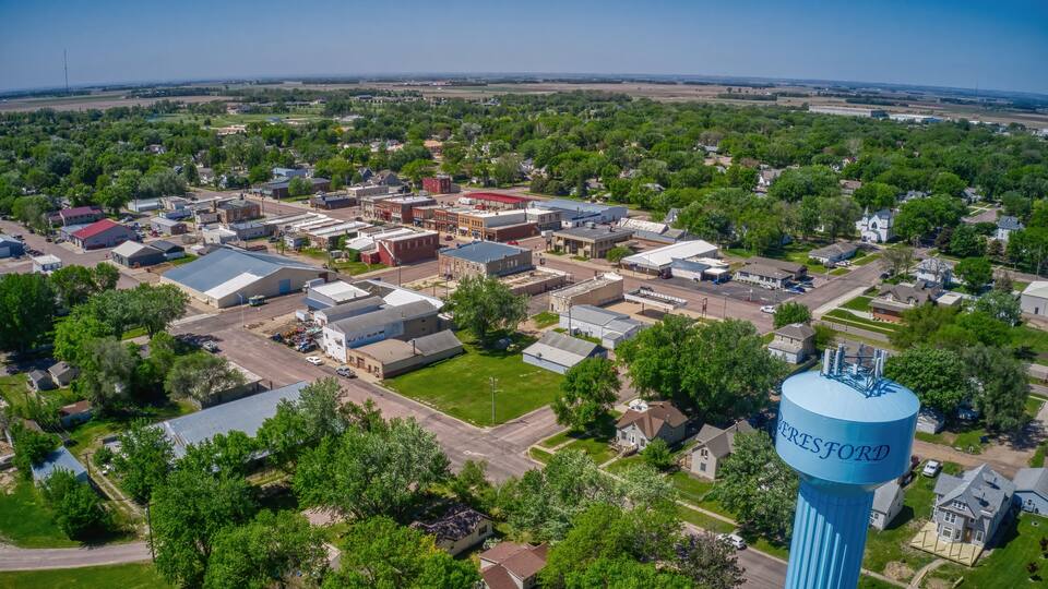 An aerial view of a town with a prominent blue water tower labeled 'VERESFORD' and various buildings, roads, and greenery.