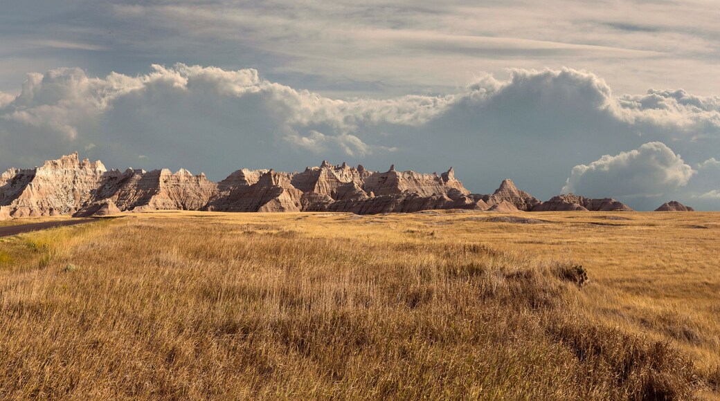 Panorama of badlands national park with vista of mountain range with large clouds in background