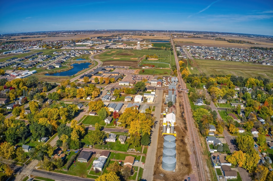 Vista aérea de una ciudad con una extensa zona industrial, un campo deportivo y barrios residenciales circundantes.