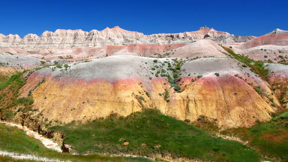 A colorful landscape with rolling hills and a river.