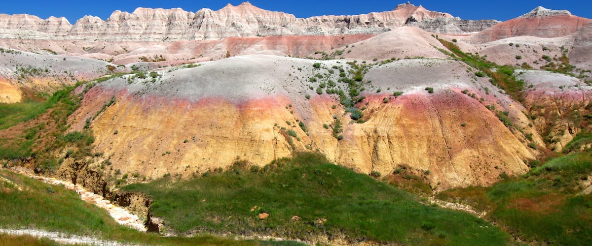 A colorful landscape with rolling hills and a river.