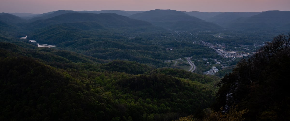 A mountainous landscape with a winding river and a valley below.