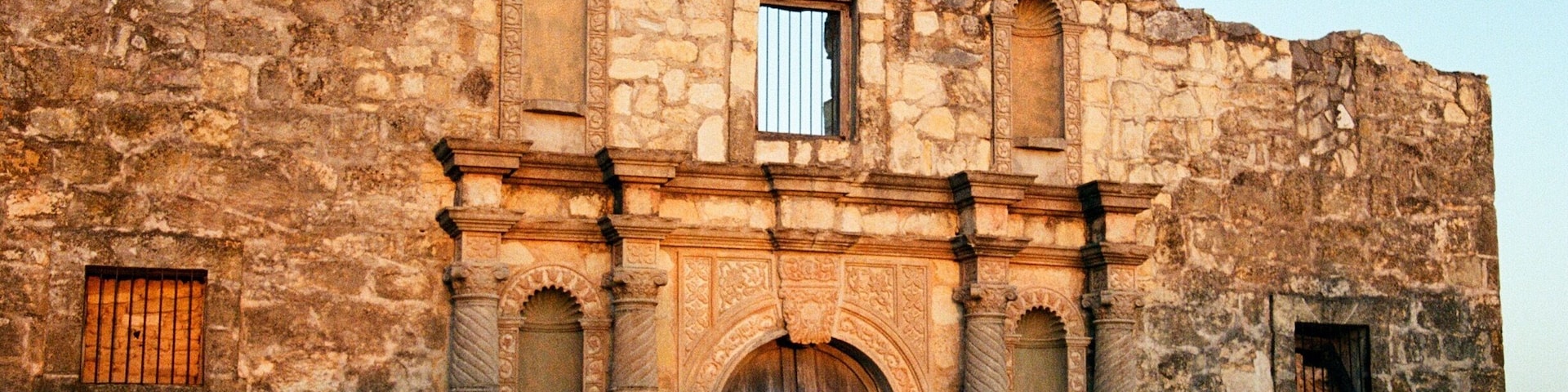 An old stone building with arched windows and a central doorway.