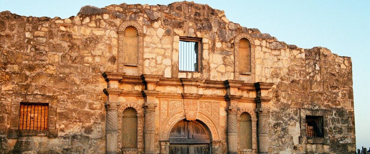 An old stone building with arched windows and a central doorway.
