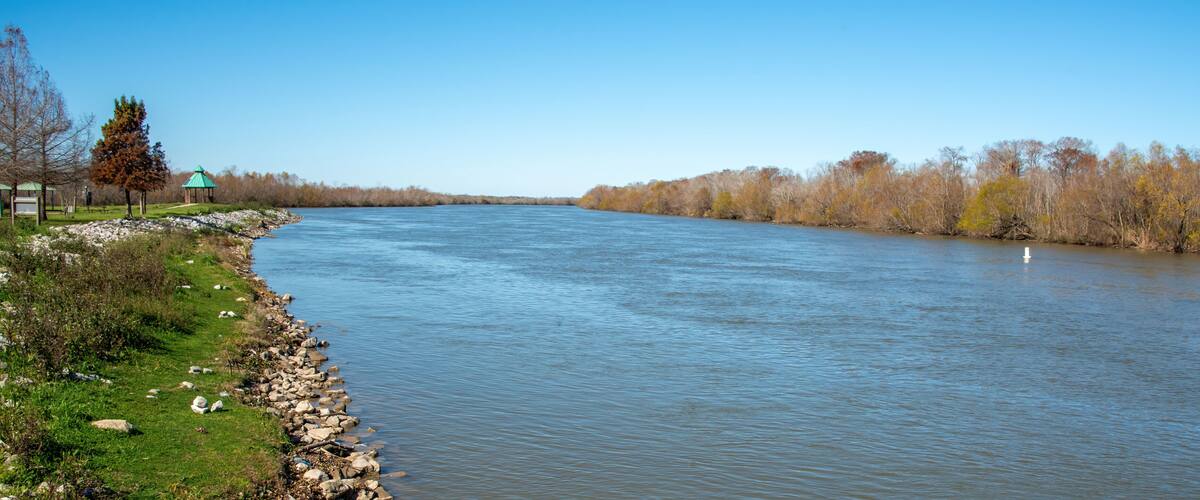 A river with a gazebo and a path along the bank.