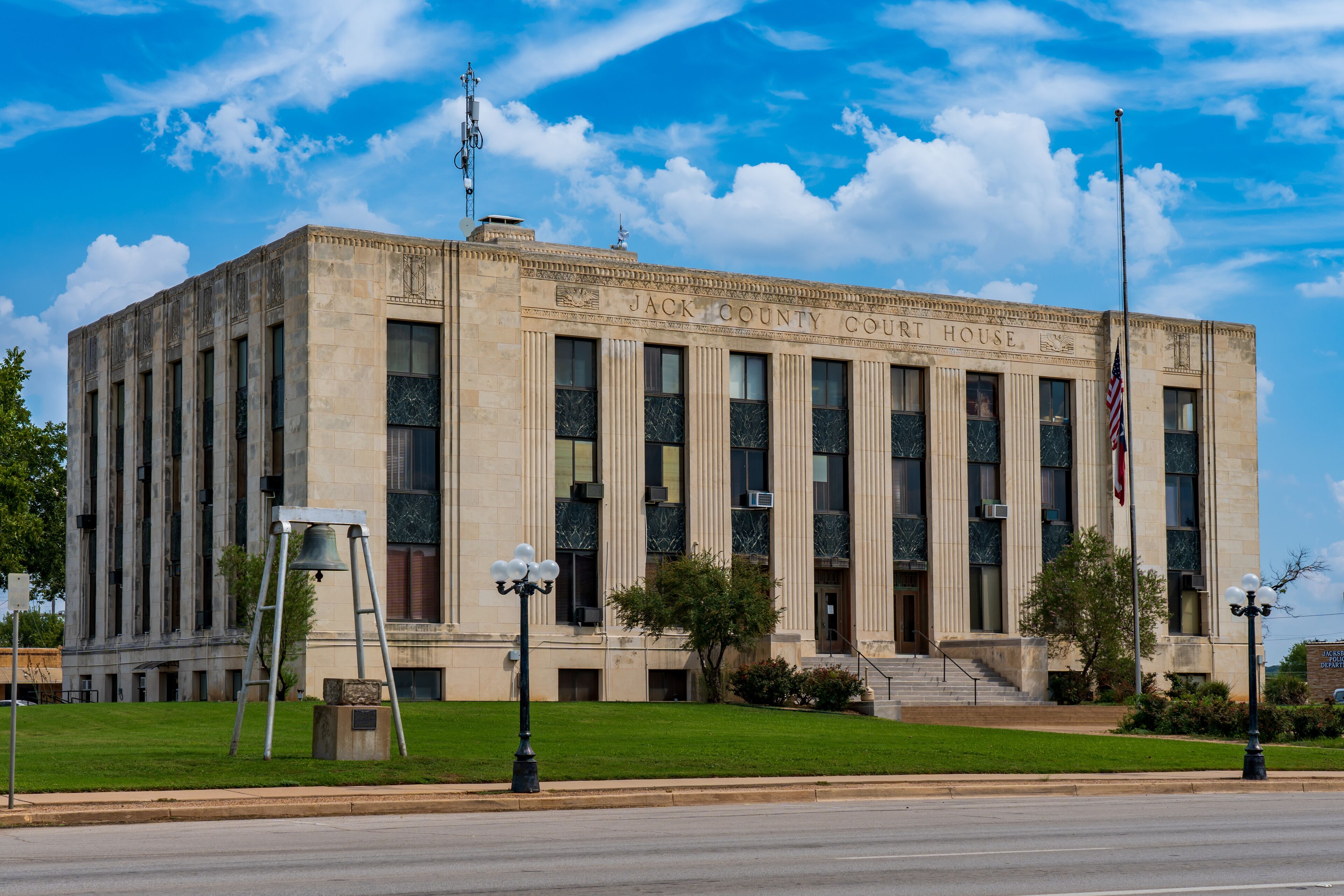 The Jack County Courthouse with a clear blue sky and clouds.