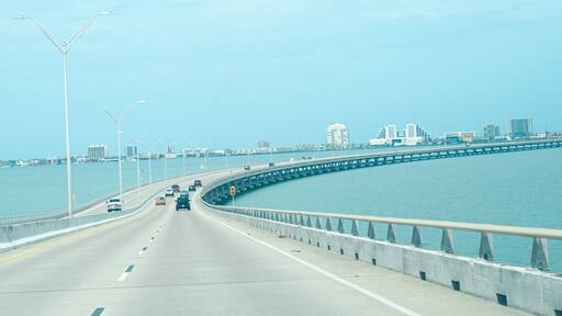 Panorama view Queen Isabella Memorial Bridge Causeway over Gulf Coast and South Padre Island buildings background, concrete pier-and-beam bridge, steel cantilever main beam span from Port Isabel