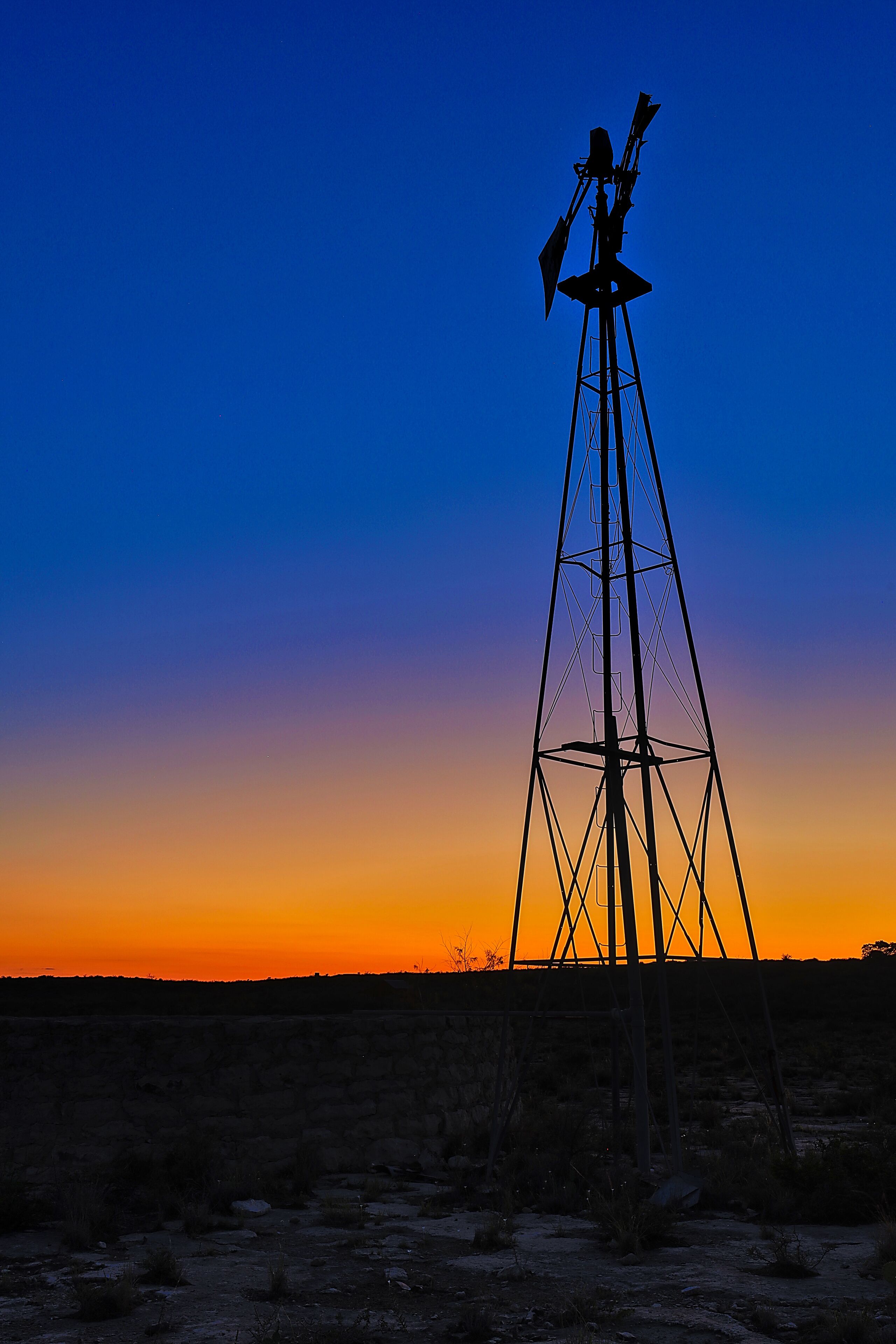 Sunset at Seminole Canyon State Park behind an old windmill and stock tank.