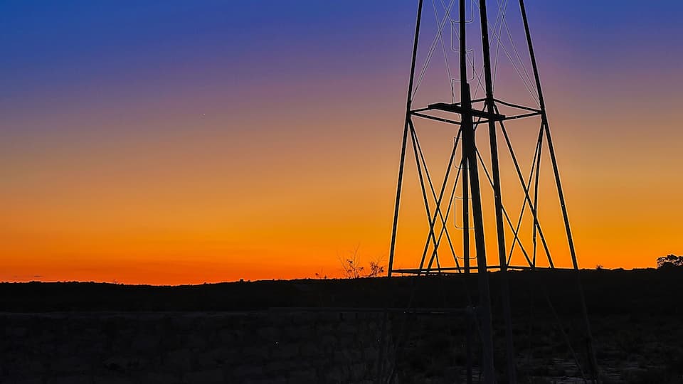 A windmill silhouetted against a sunset sky.