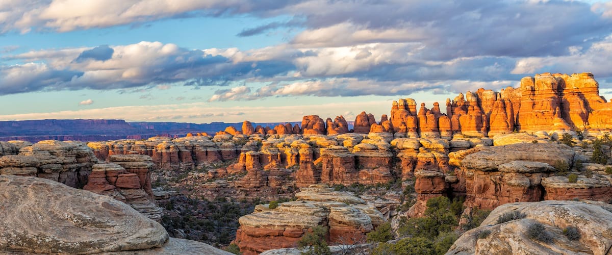 A canyon with layered rock formations and a cloudy sky.