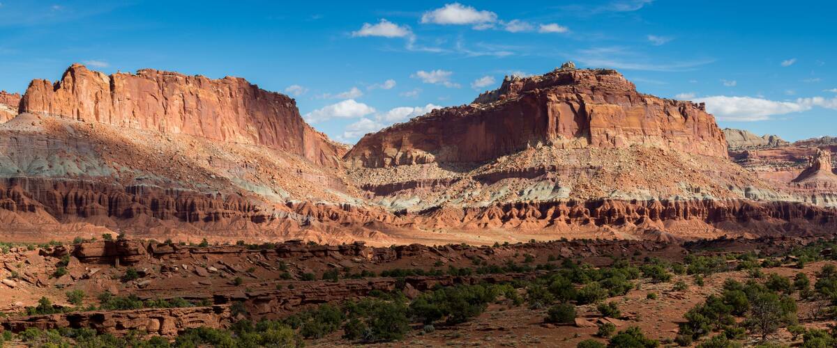 A rugged mountain range with layered rock formations and sparse vegetation.