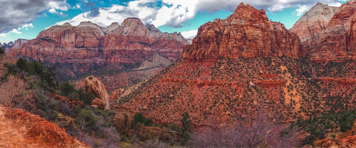 A canyon with red rock formations and a winding road.