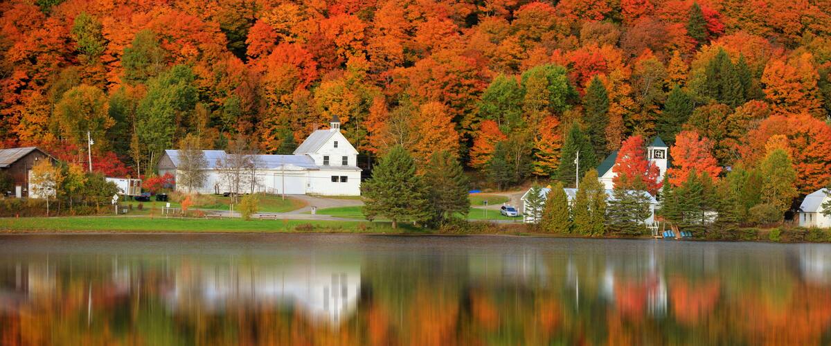 Panoramic view of old barn by the lake with fall foliage near Danville, Vermont