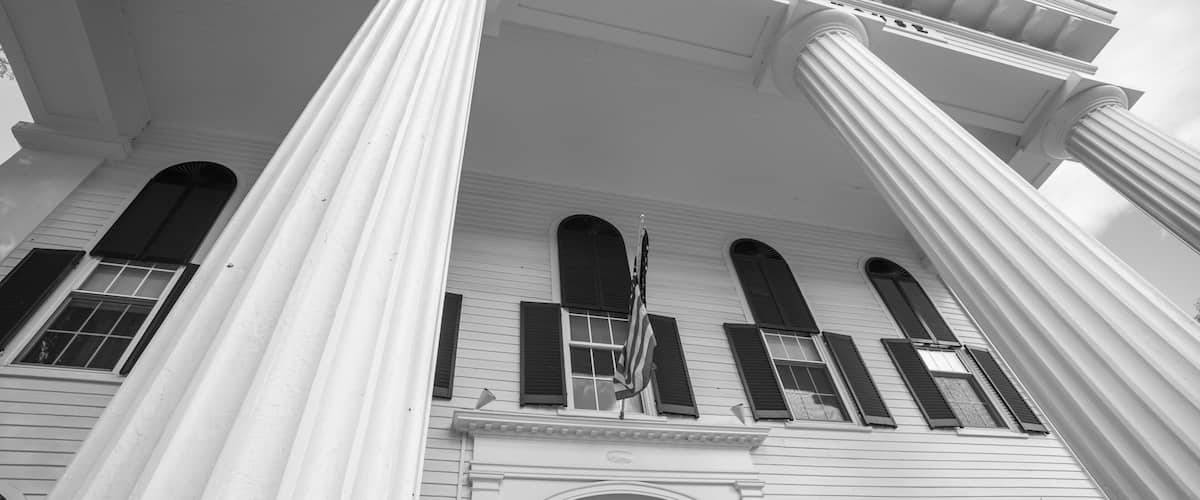 A courthouse with large columns, a prominent entrance, and an American flag.