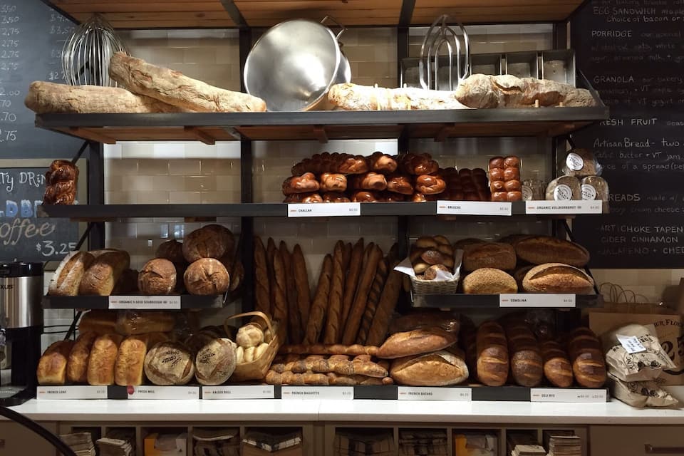 A bakery display with various breads and pastries.