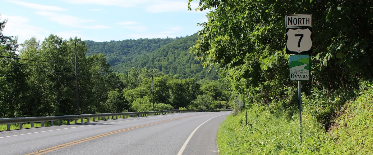 A highway with a North 7 sign, surrounded by lush greenery and hills.