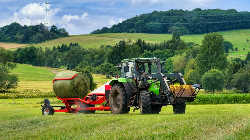 Tractor loading bales of hay
