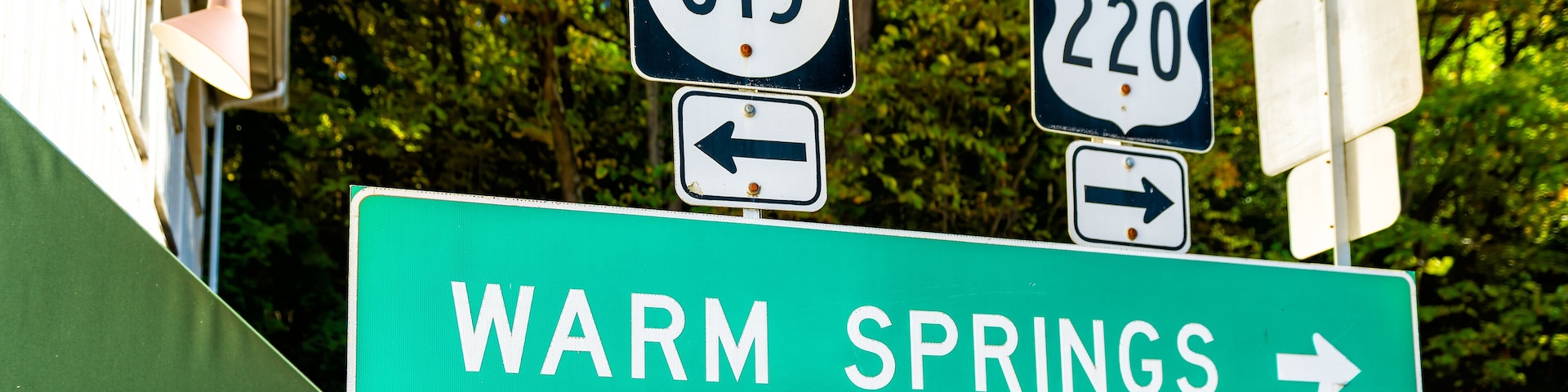 Señal de tráfico para las carreteras 615 y 220 al norte, y una señalización para Warm Springs.