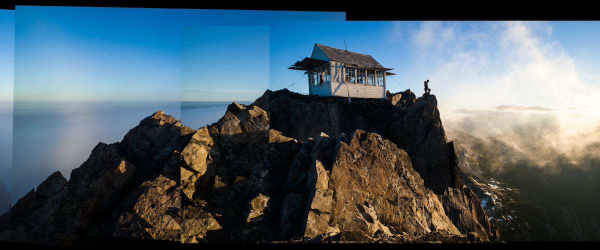 Hiker stands at sunrise outside Three Fingers Lookout, North Cascades