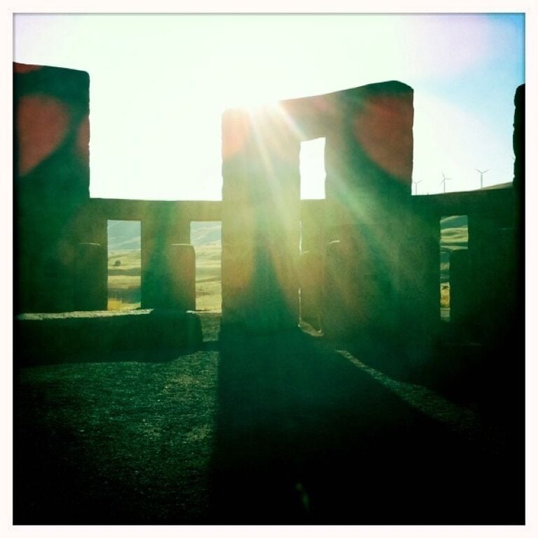 A sunlit ruin with columns and a clear sky.