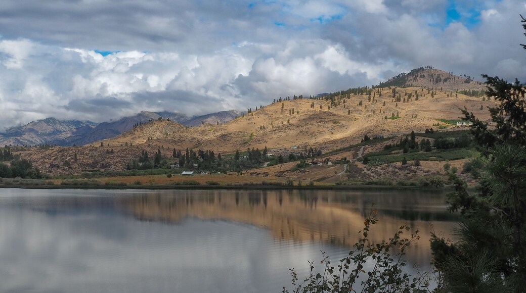 Brown desert mountains surround Wapato Lake which reflects the beautiful cloudy skies near Manson in Eastern Washington State.