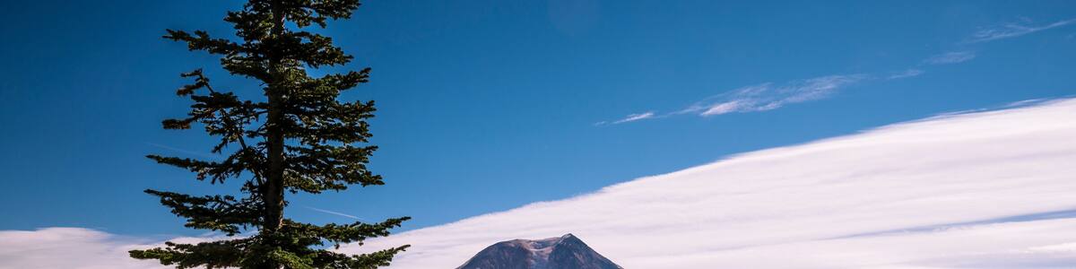 Female standing on cliff with Mount Adams in the background