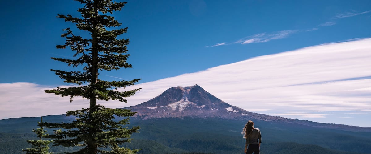 Female standing on cliff with Mount Adams in the background