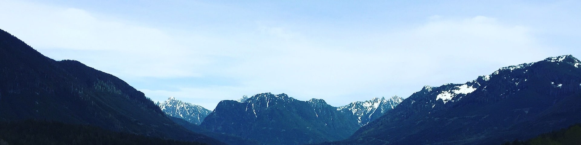 A calm lake surrounded by mountains with snow-capped peaks.