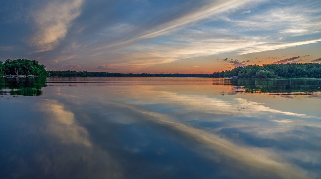 Bright sunset with reflections of clouds on the calm water during summer on Big Moon Lake, Barron County WI