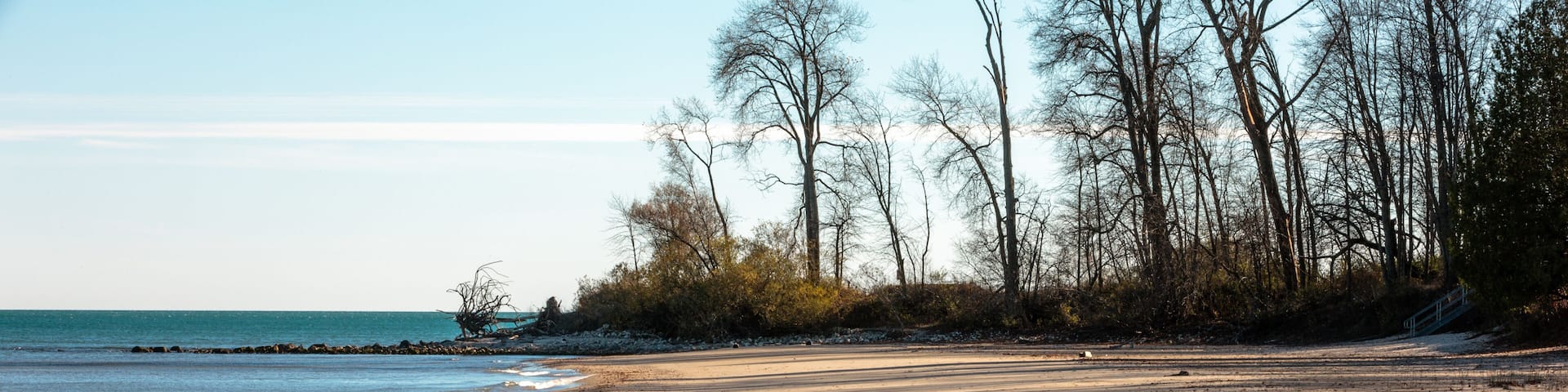 The silent beach scene, now covered with the streaking shadows from the afternoon lowering sun, at Harrington Beach State Park, Belgium, Wisconsin in early November