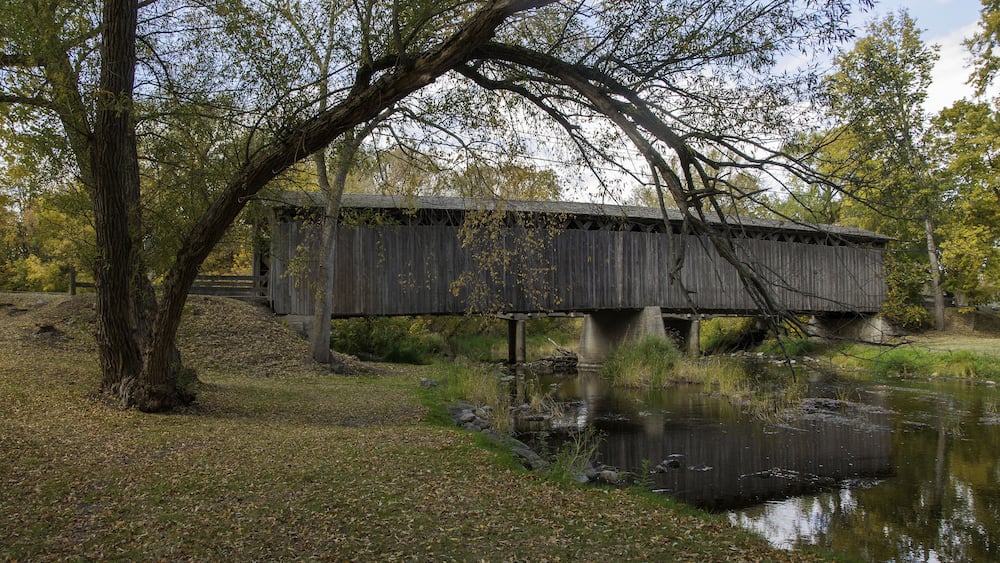 Photograph of a historical covered bridge crossing a southern Wisconsin river near Cedarburg