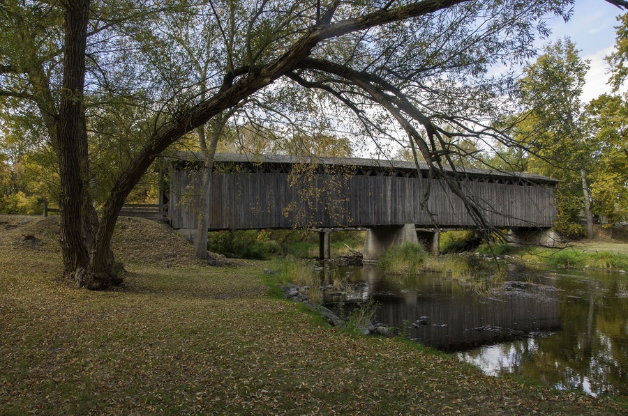 Photograph of a historical covered bridge crossing a southern Wisconsin river near  Cedarburg