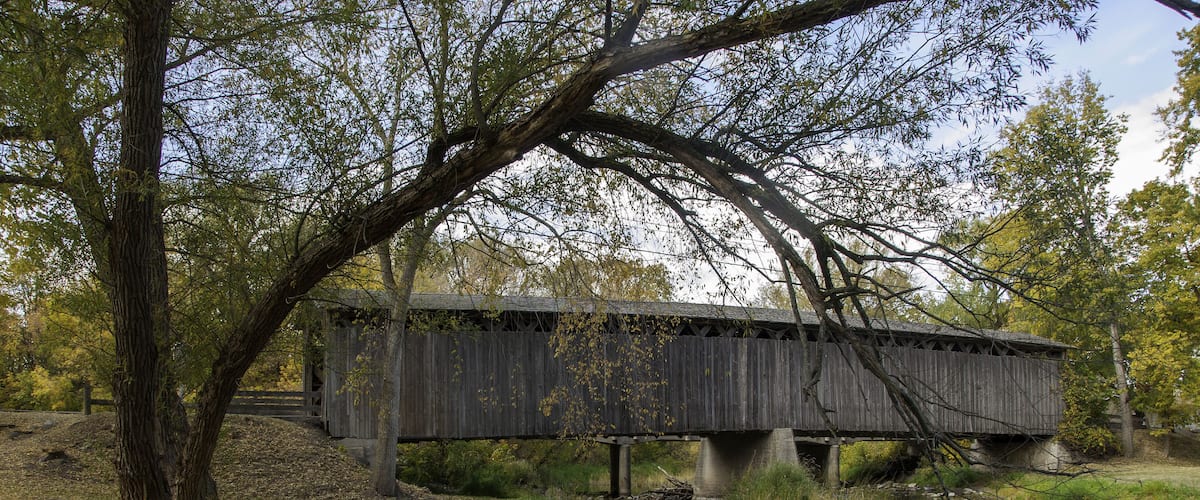Photograph of a historical covered bridge crossing a southern Wisconsin river near Cedarburg