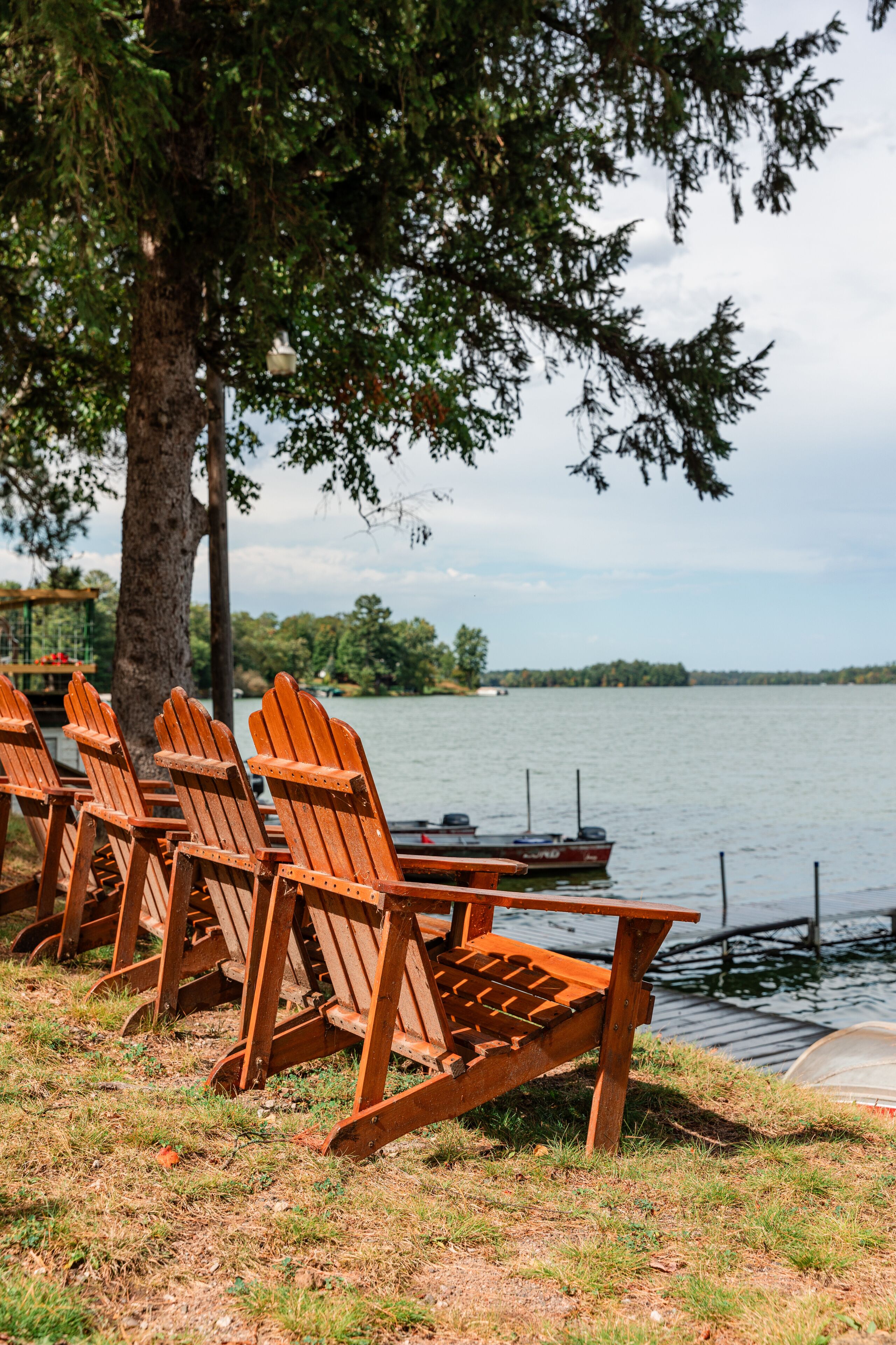 Adirondack chairs facing lake at shoreline