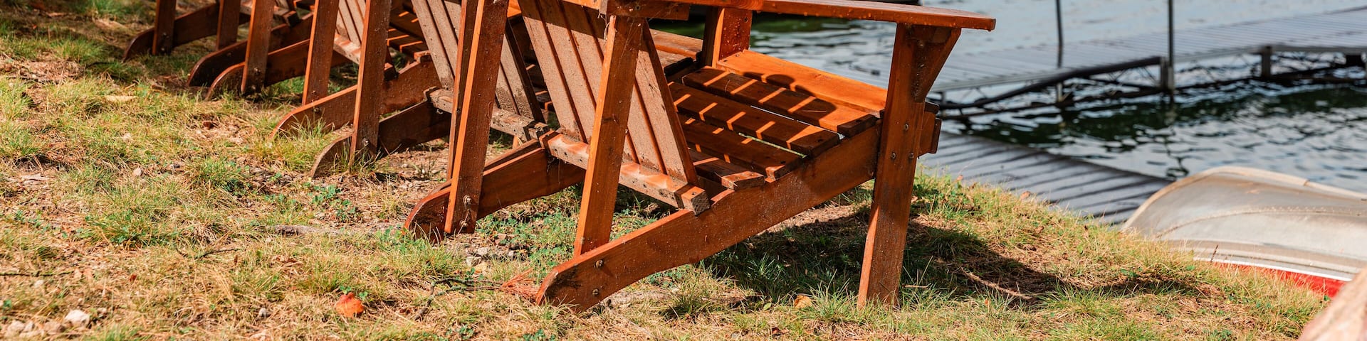 Adirondack chairs facing lake at shoreline