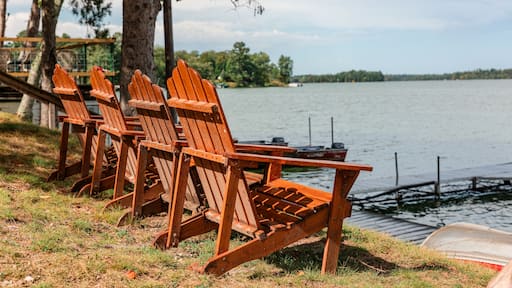 Adirondack chairs facing lake at shoreline