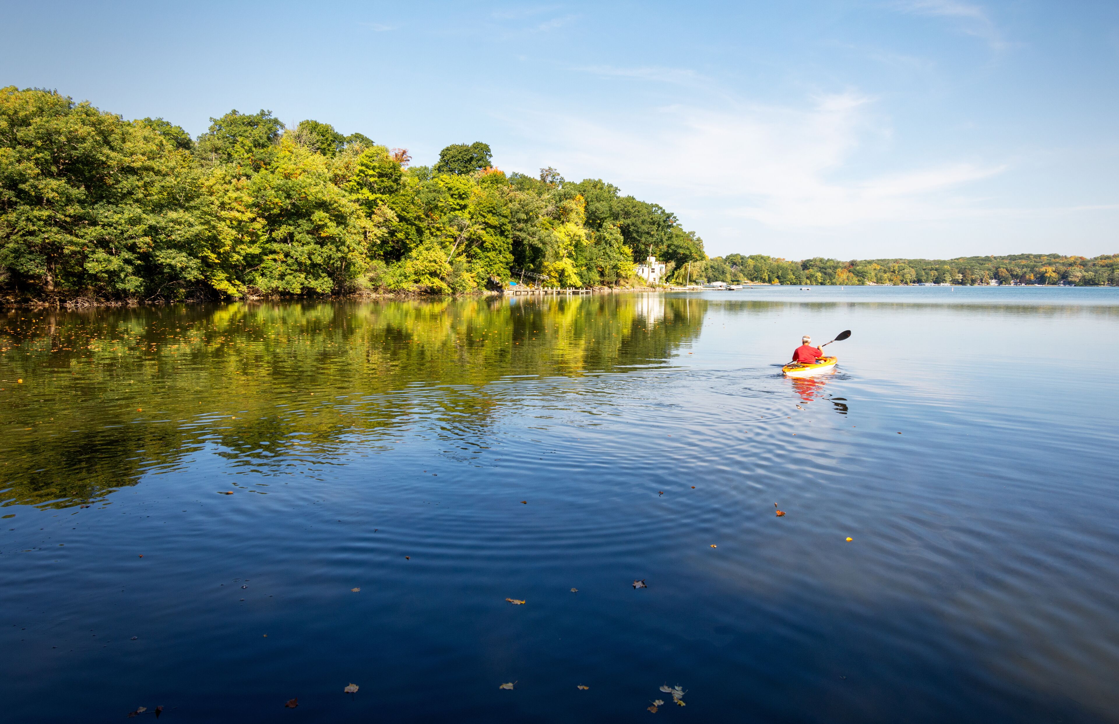A Kayaker takes to the water on a warm October morning on a lake in Wisconsin.