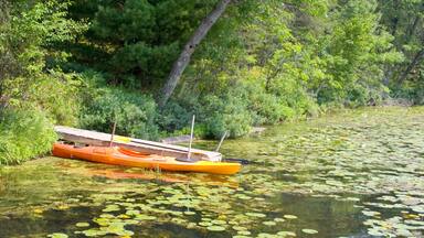 Kayak moored at dock in bed of lily pads. Gull Lake Danbury Wisconsin USA