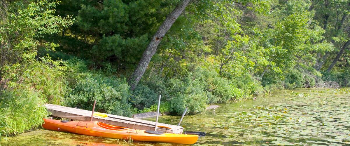 Kayak moored at dock in bed of lily pads. Gull Lake Danbury Wisconsin USA