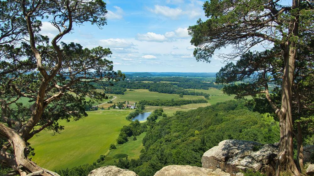 Sunny Summer day landscape of lush green fields and forests as seen from the top of Gibraltar Rock near Lodi, Wisconsin.