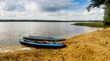 a three kayaks on the beach of Ostriv'yanske lake of Shatskyi Lakes group, Shatsk National Natural Park, Volyn region of Western Ukraine