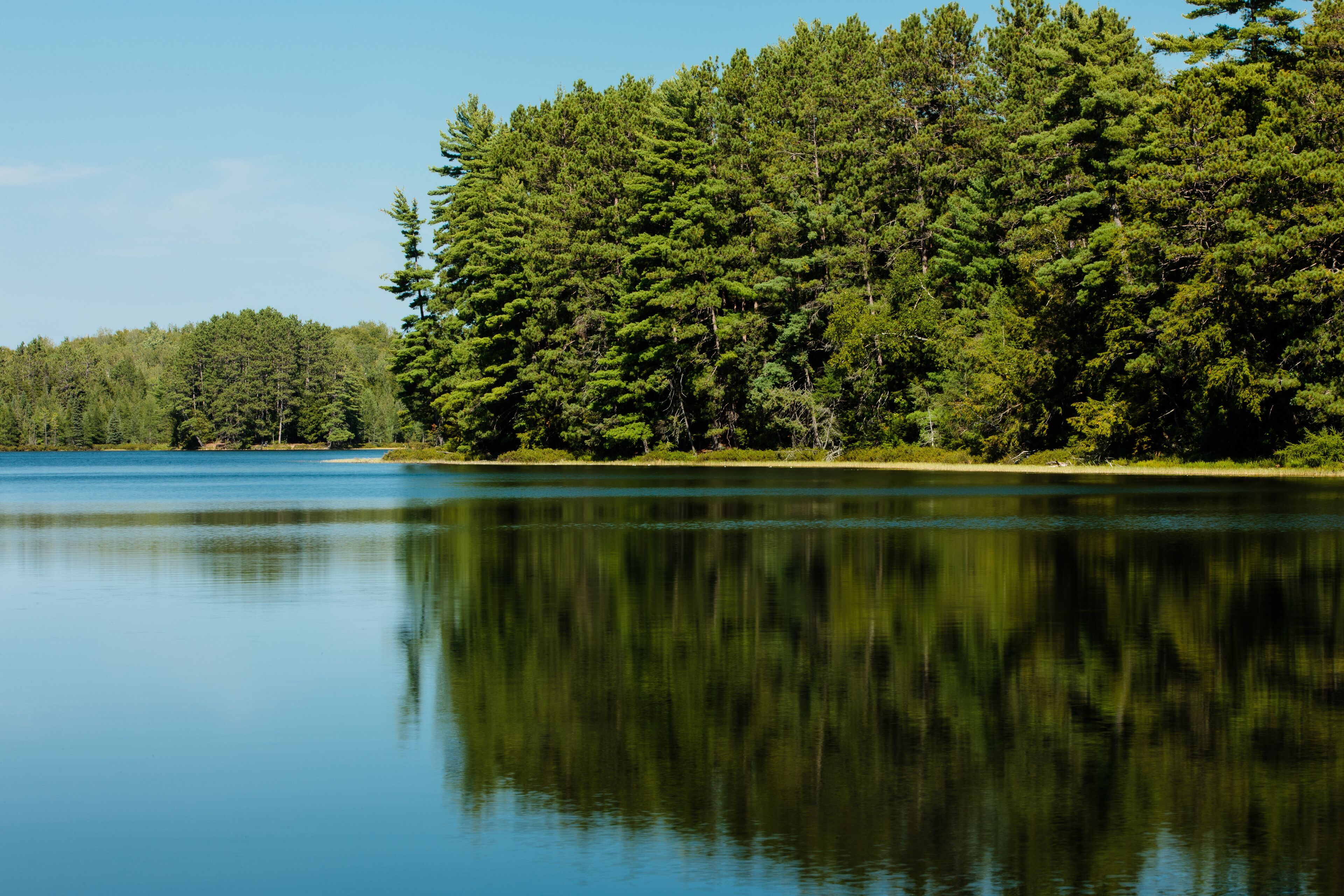 Hemlock Lake, in late August, invites the canoer to enjoy the calm waters, in Oneida County, near Woodruff, Wisconsin.
