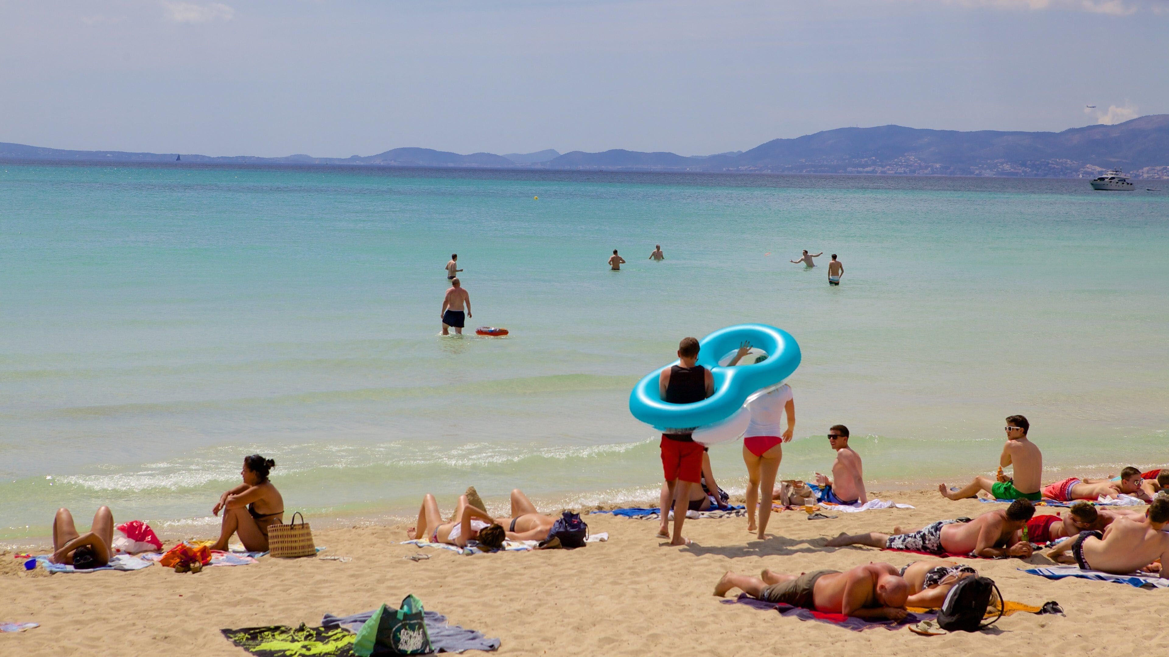 El Arenal featuring a beach as well as a large group of people