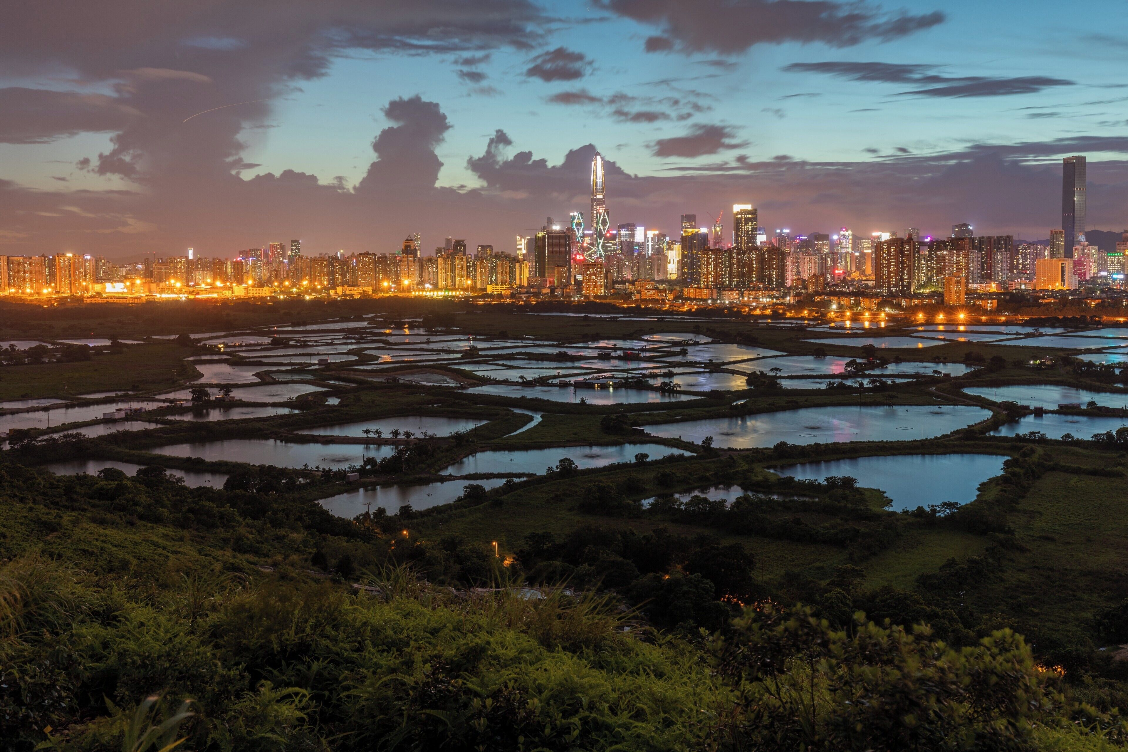 This is a great location for a sunset shoot contrasting fish farms in rural Hong Kong with the built up city of Shenzhen.

To get there you can take the 76K bus from either Yuen Long of Sheung Shui, get off at Ho Sheung Heung then take the green mini bus 51B from around the corner to Ma Tso Lung Shun Yee San Tsuen. From there it&#x27;s a 150m hike up the old road to the former police post. The best spot is a hill just to the north of the police post.