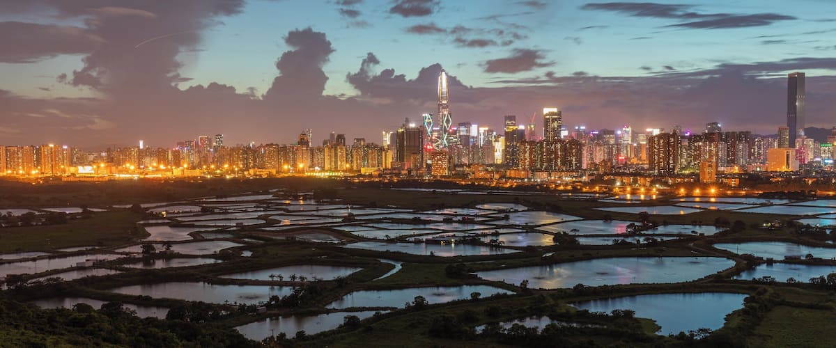 This is a great location for a sunset shoot contrasting fish farms in rural Hong Kong with the built up city of Shenzhen.
To get there you can take the 76K bus from either Yuen Long of Sheung Shui, get off at Ho Sheung Heung then take the green mini bus 51B from around the corner to Ma Tso Lung Shun Yee San Tsuen. From there it's a 150m hike up the old road to the former police post. The best spot is a hill just to the north of the police post.
